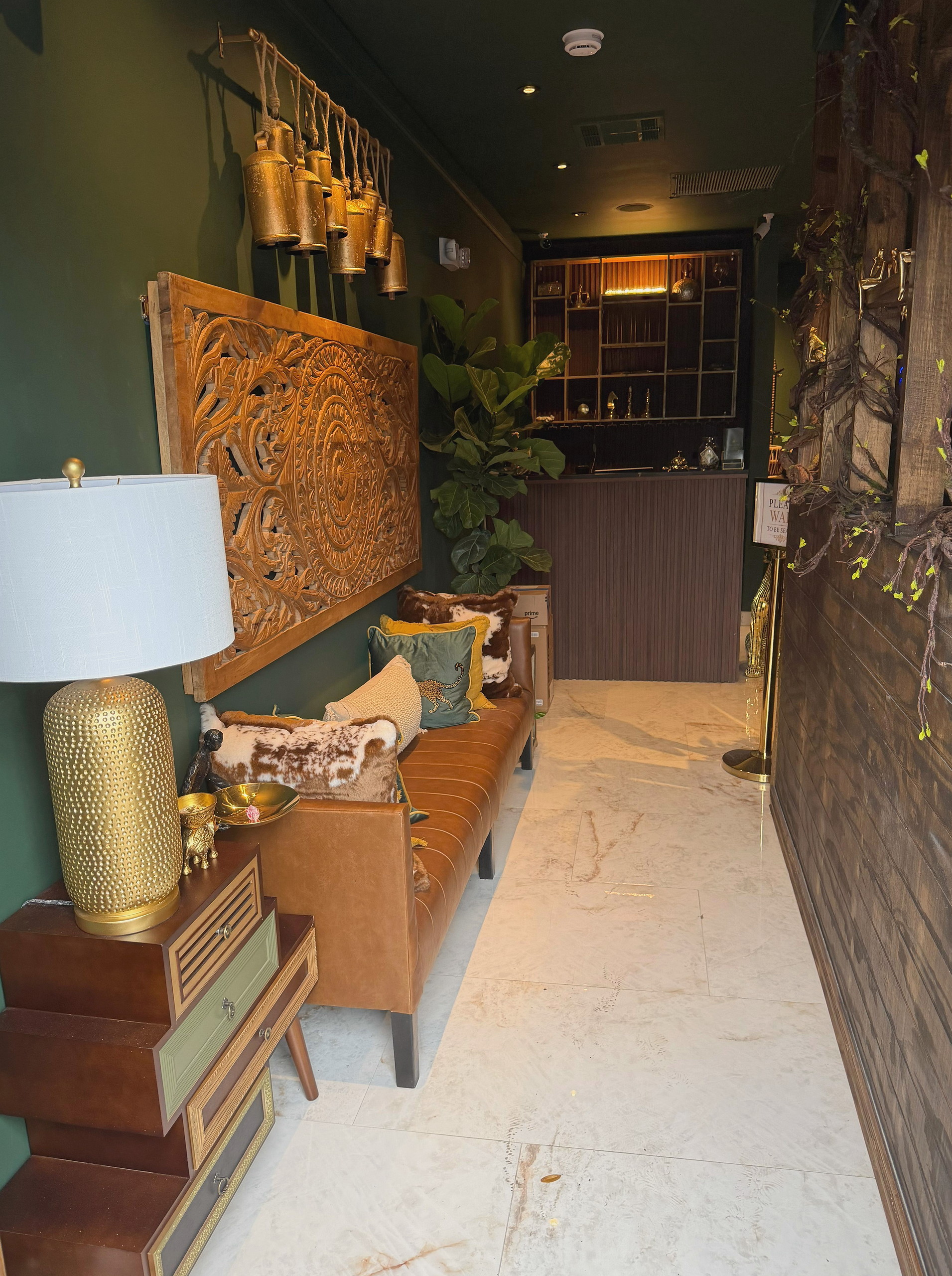 The first room of the house — carved wood, brass bells, marble underfoot.